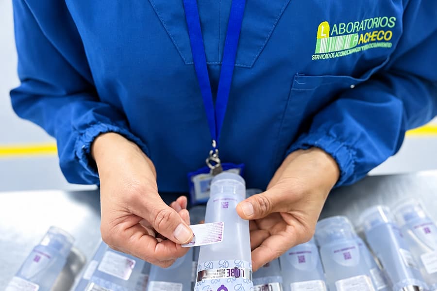 Operaria colocando una etiqueta sobre el envase